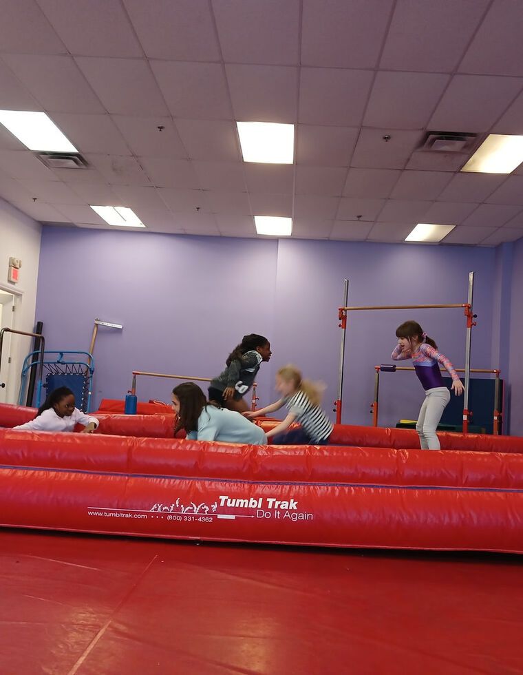 Des campeurs sur la piste de tumbling du gymnase de CMD