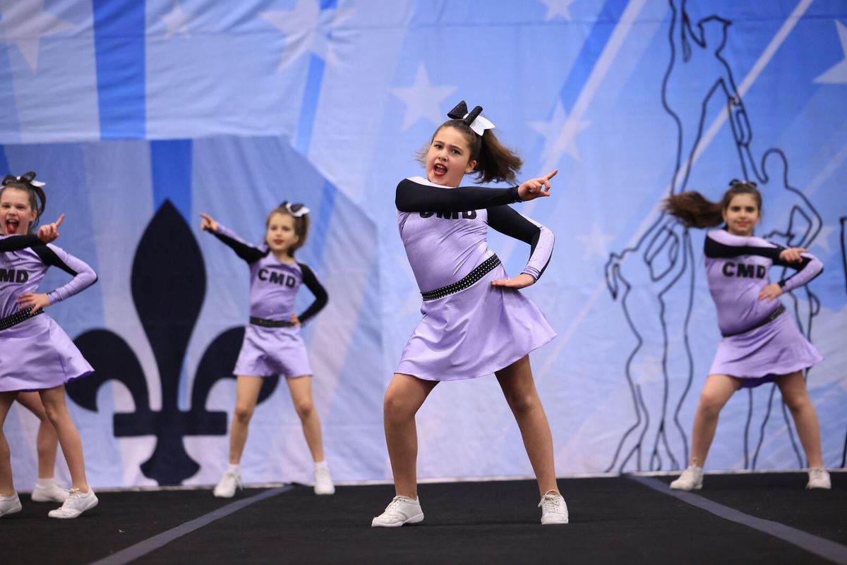 Des cheerleaders de CMD en uniforme lilas sur le plancher de compétition